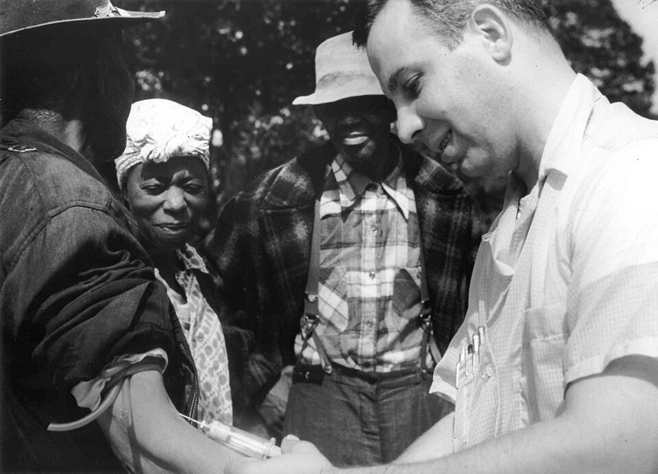 Un médecin du U.S. Public Health Service effectue une prise de sang sur un participant noir de l'étude Tuskegee